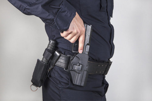 Policeman drawing a gun from his holster